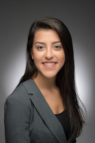 Professional headshot of Thalita Neves smiling at the camera in a gray blazer.