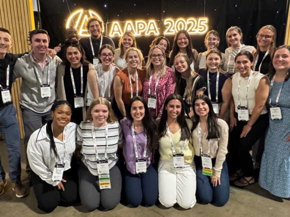 Students stand in a group in front of logo for AAPA 2025 Conference