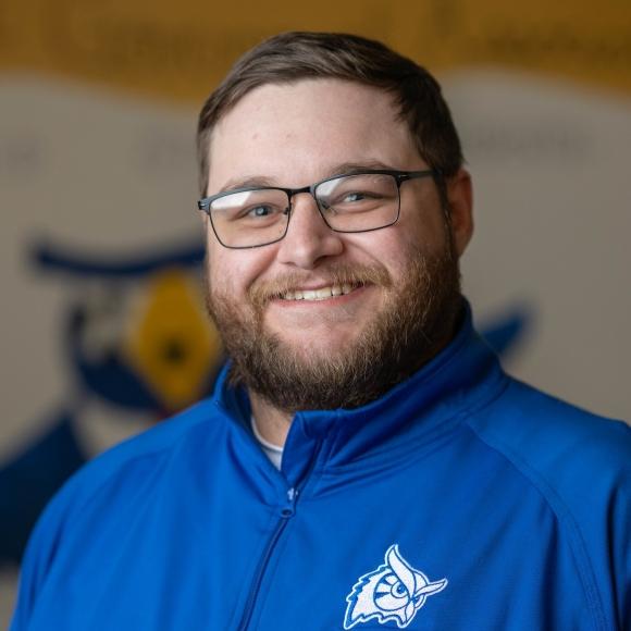 SGA Executive Secretary, Jacob wearing a blue shirt smiling.