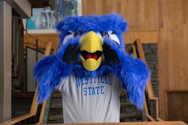 Nestor the mascot gestures with their hands to communicate.